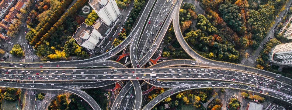 An overhead shot of a complex motorway junction. Photo by Denys Nevozhai on Unsplash.